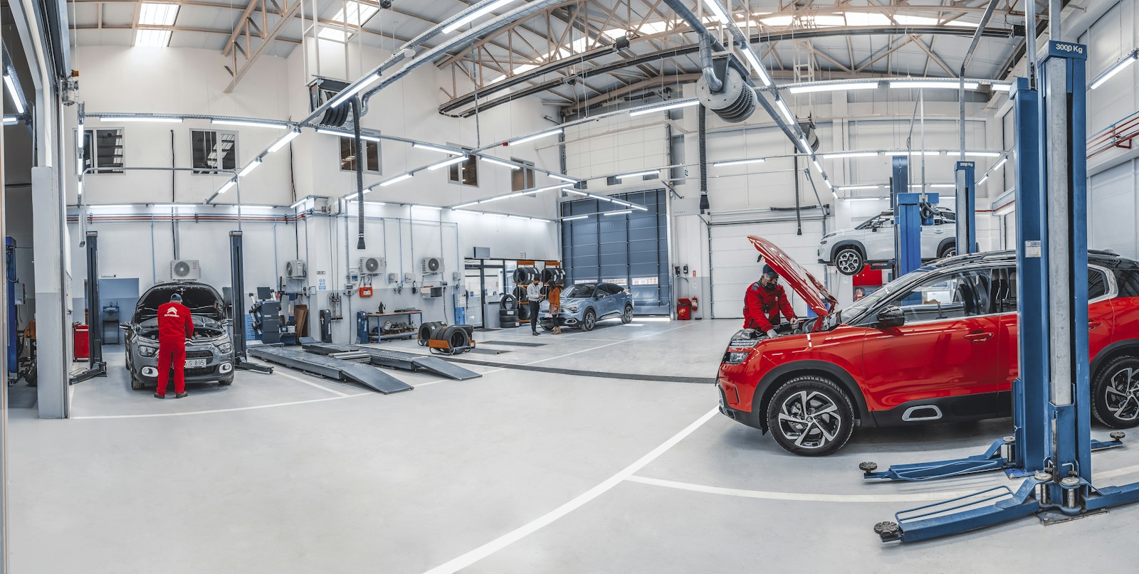 Técnicos trabalham em oficina automotiva iluminada
